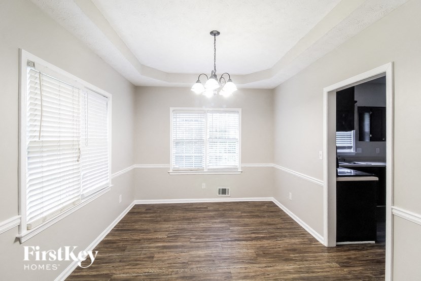an empty living room with wood flooring and white walls