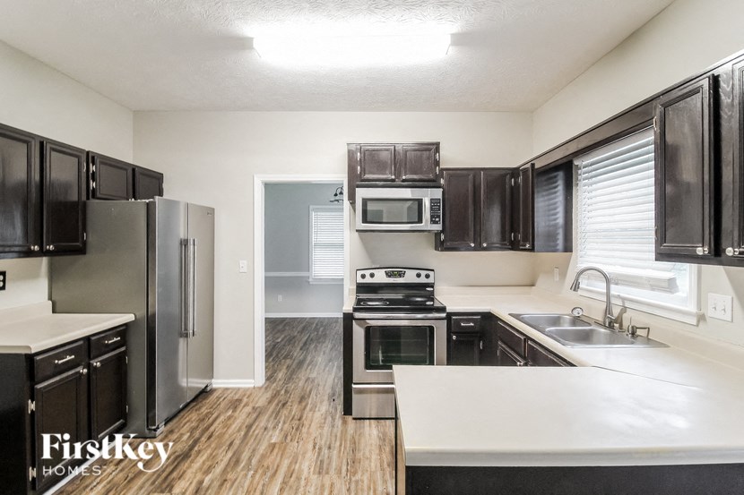 a kitchen with black cabinets and stainless steel appliances