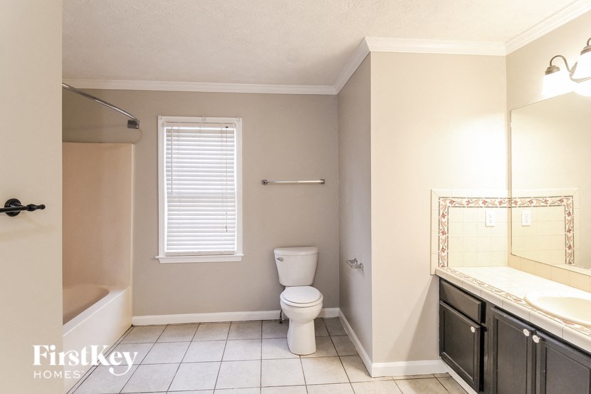 a bathroom with a toilet and a sink and a mirror
