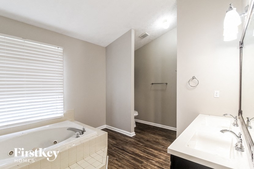 a bathroom with a tub and a sink and a mirror