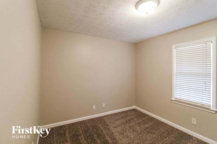 the upstairs bedroom with carpet and a large window