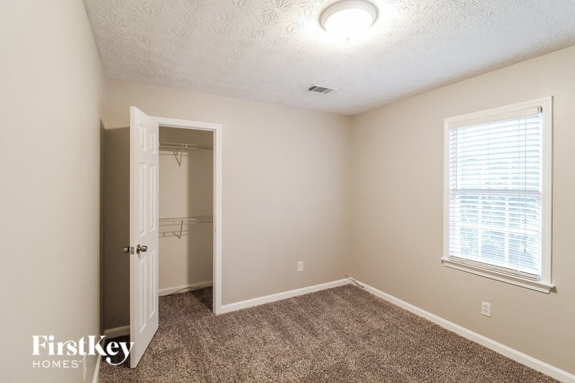 a bedroom with a closet and a door to a bathroom