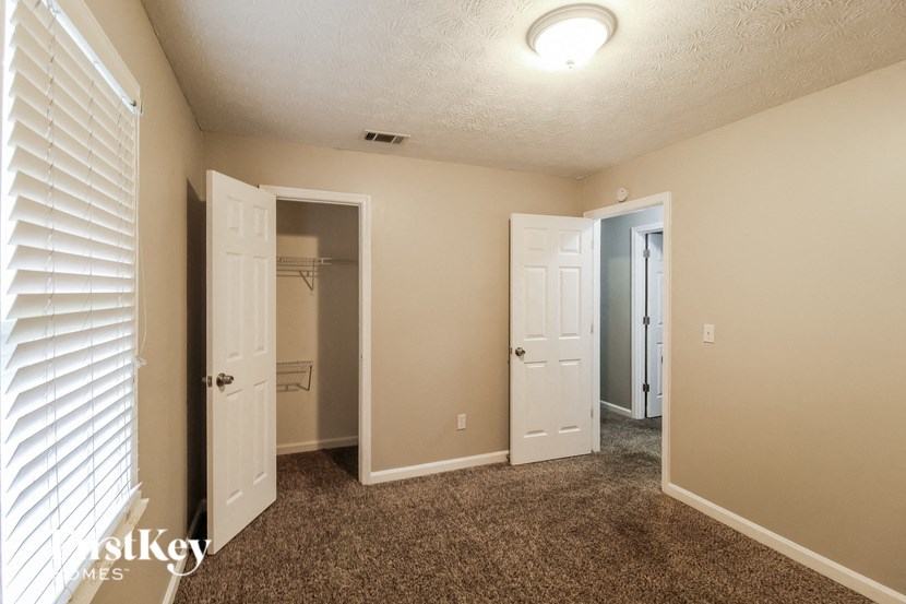 a bedroom with a closet and a door to a bathroom