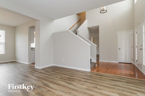 a renovated living room with a hardwood floor and a staircase