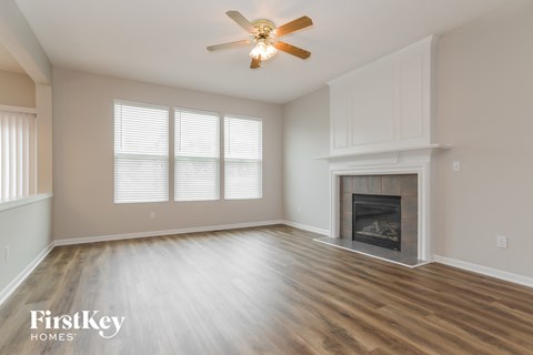 a living room with a fireplace and a ceiling fan