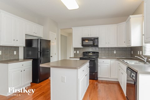 a renovated kitchen with white cabinets and black appliances
