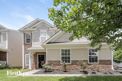 a white house with a tree in front of it
