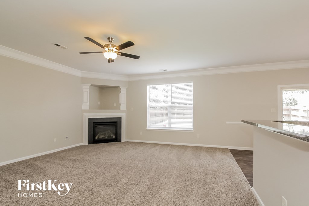 a living room with a fireplace and a ceiling fan