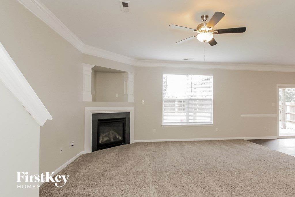 the living room with fireplace and ceiling fan