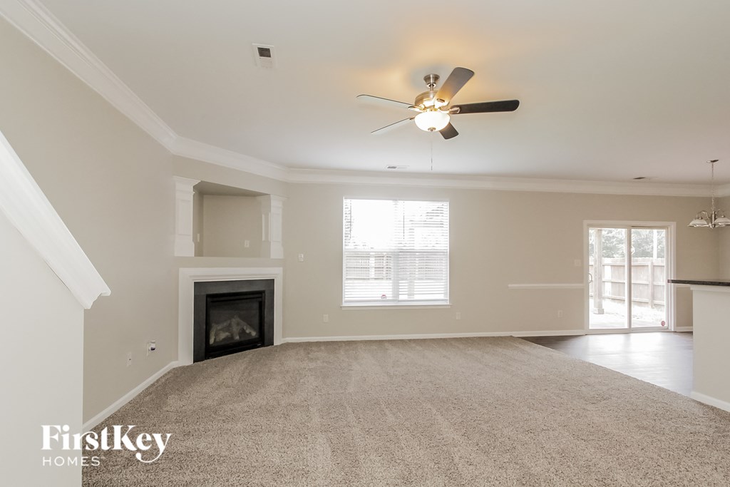a living room with a fireplace and a ceiling fan