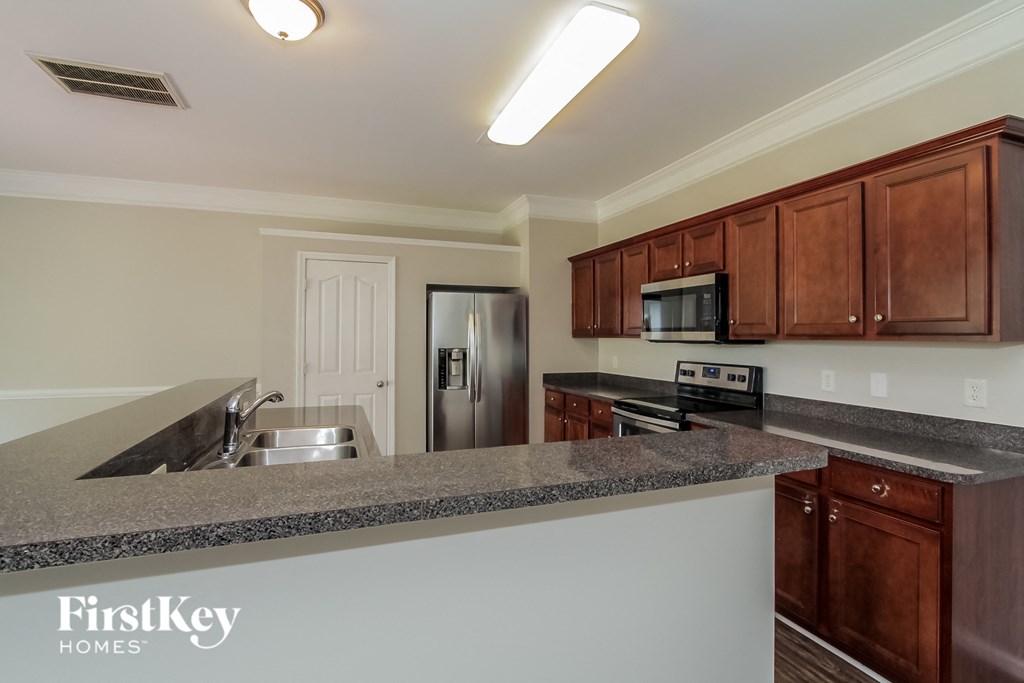 a kitchen with granite counter tops and wooden cabinets