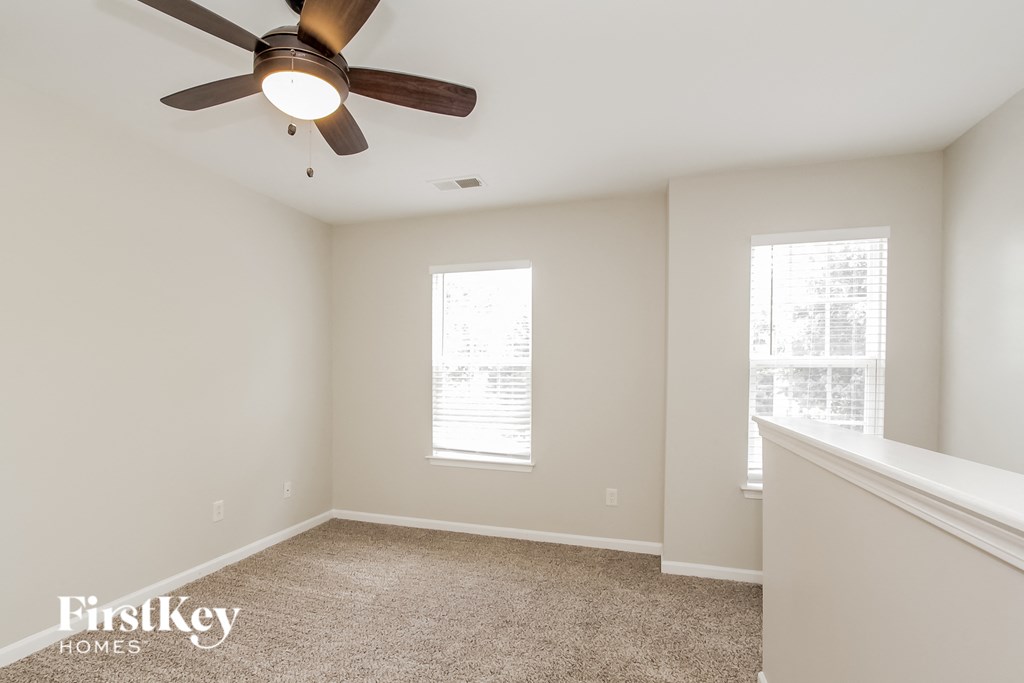 a bedroom with a ceiling fan and a window
