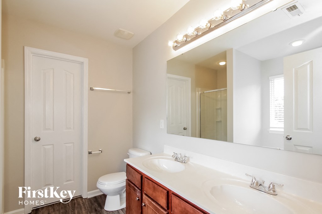 a bathroom with two sinks and a mirror and a toilet