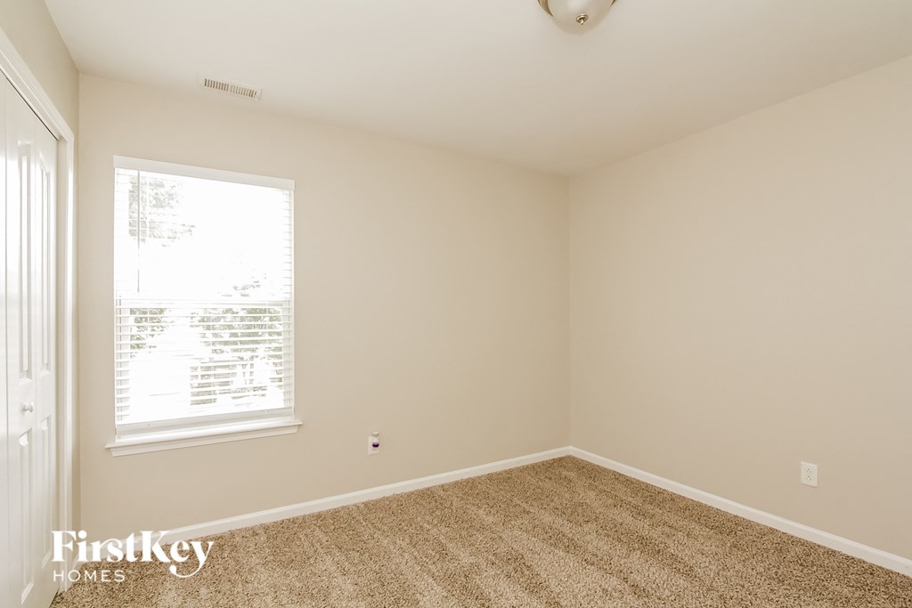 the living room of a home with a carpeted floor and a window