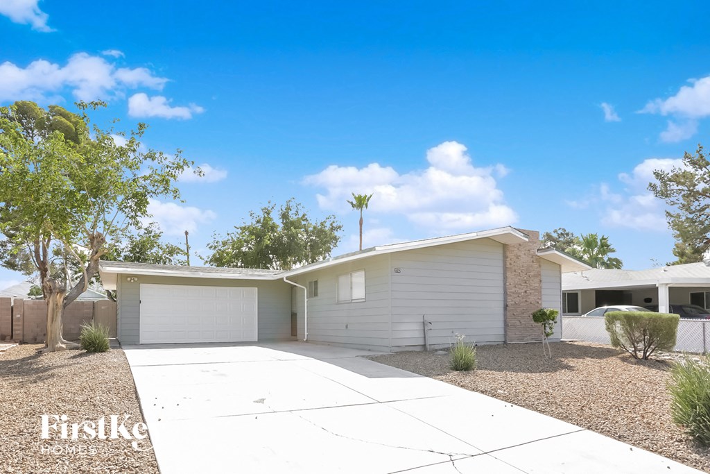 a white house with white garage doors and a driveway