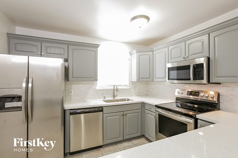 a white kitchen with stainless steel appliances and white cabinets