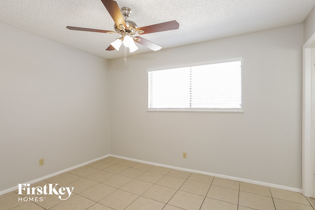 a empty room with a ceiling fan and a window