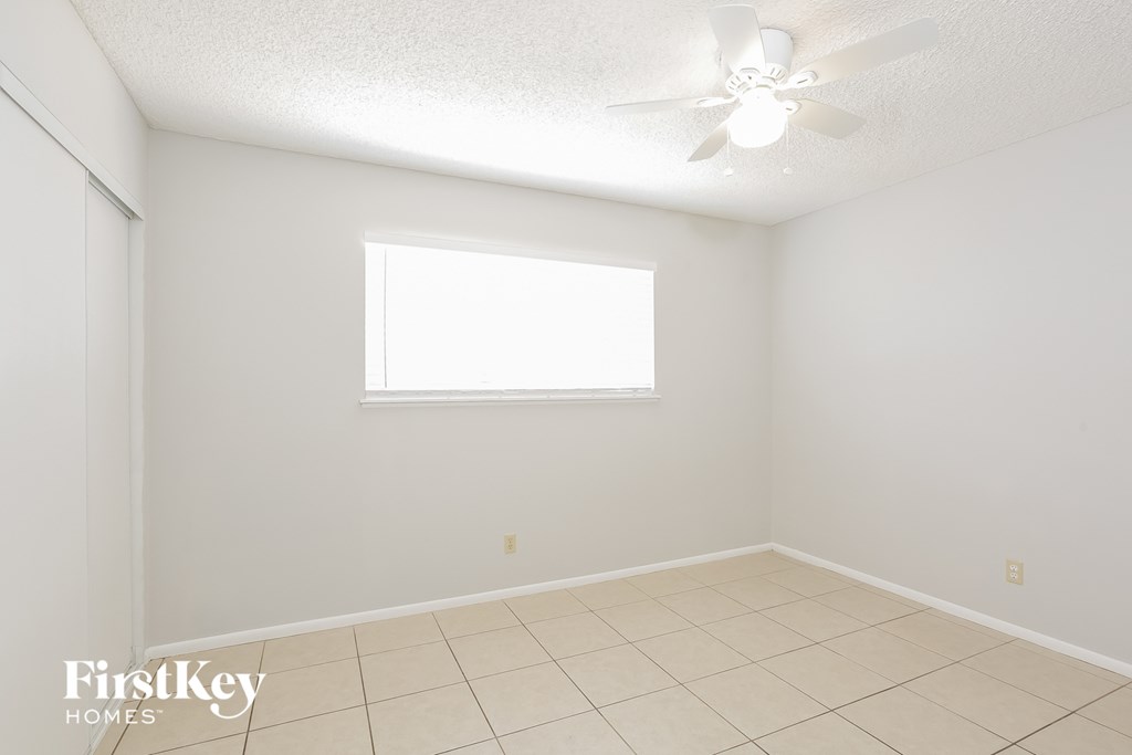 a empty room with a ceiling fan and a window
