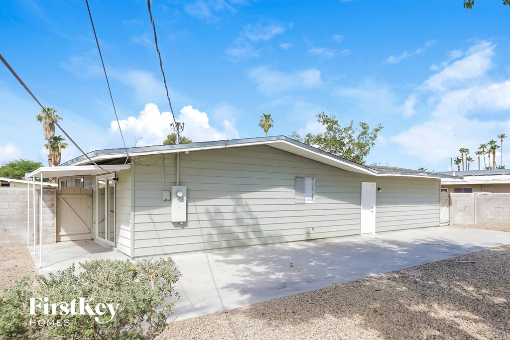 a white house with a garage and palm trees