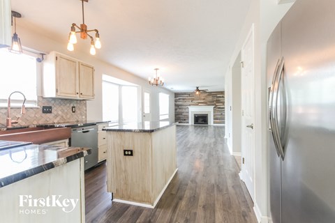 A kitchen with wooden cabinets and a stainless steel refrigerator.