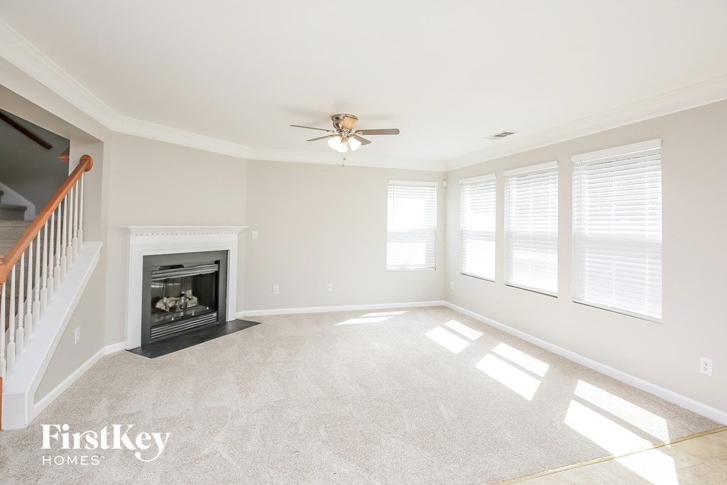 a living room with a fireplace and a ceiling fan
