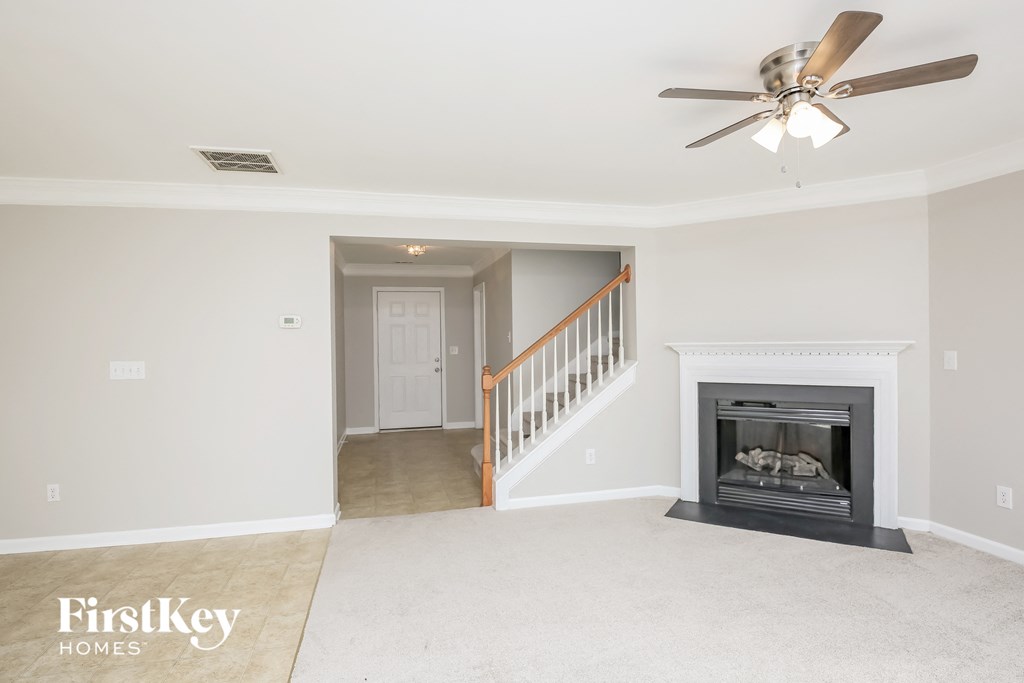 a living room with a fireplace and a ceiling fan