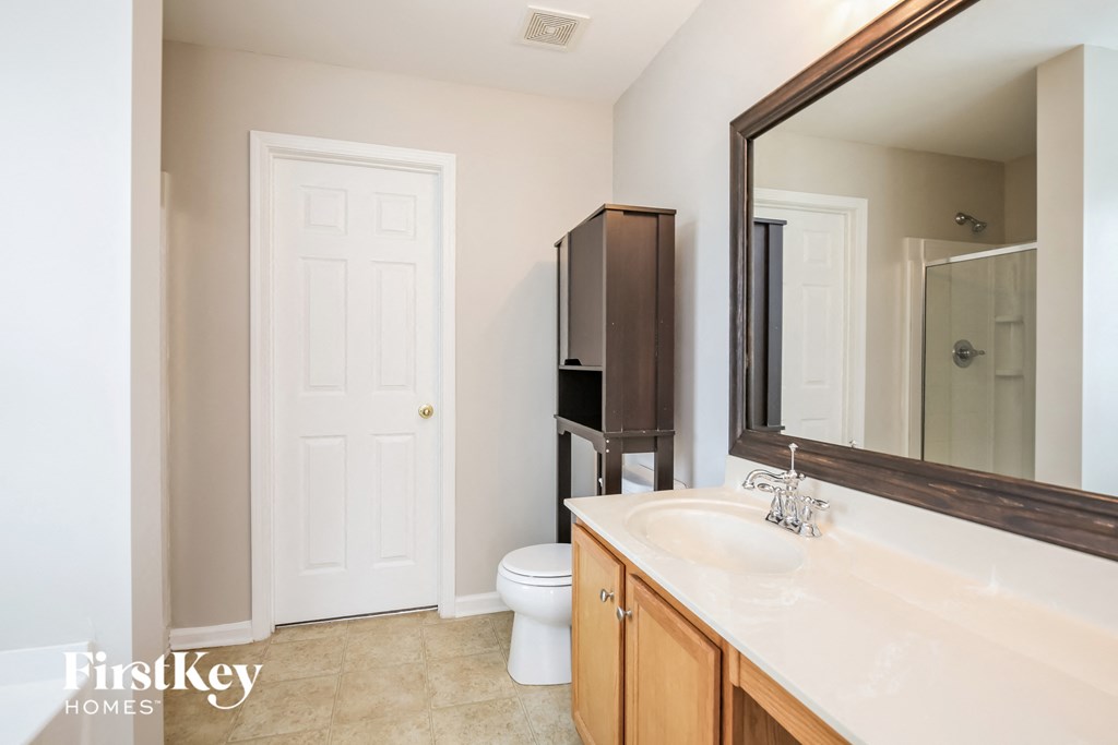 a bathroom with a large mirror and a toilet and a sink
