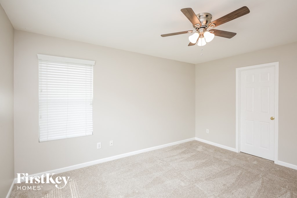 a bedroom with a ceiling fan and a white door