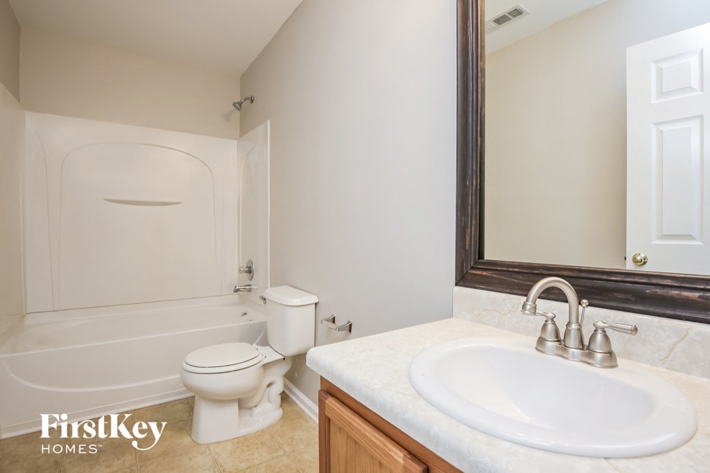 a bathroom with a sink toilet and a mirror