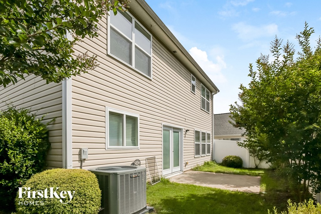a side view of a house with a cooling unit in the yard