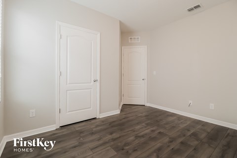 a bedroom with two doors and a door to a closet