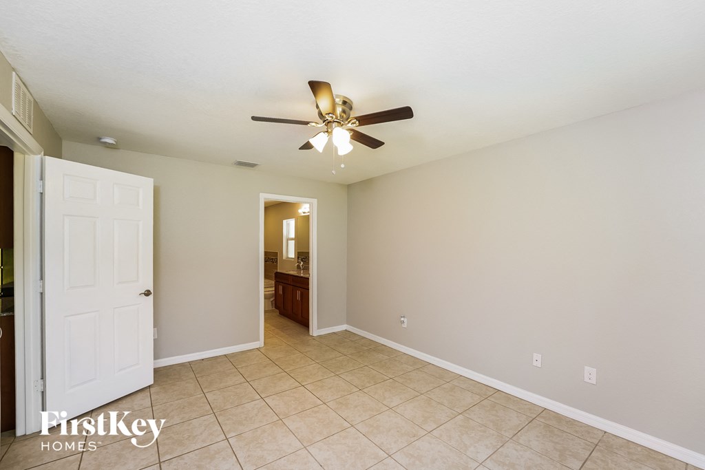 a living room with a ceiling fan and a tiled floor