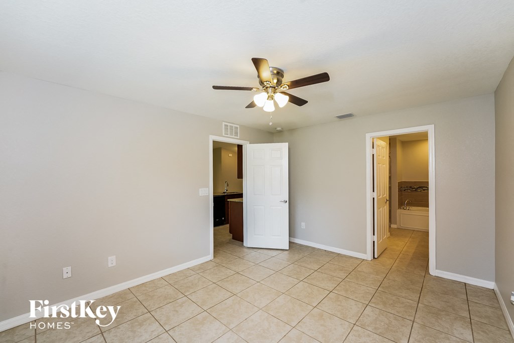 a living room with a ceiling fan and a tiled floor