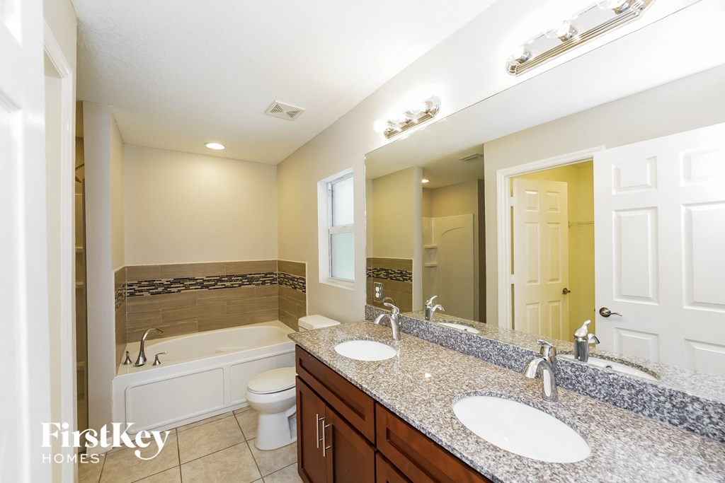 a bathroom with two sinks and a tub and a mirror