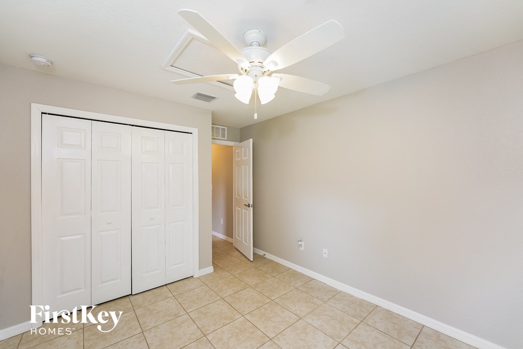 a bedroom with a ceiling fan and a closet