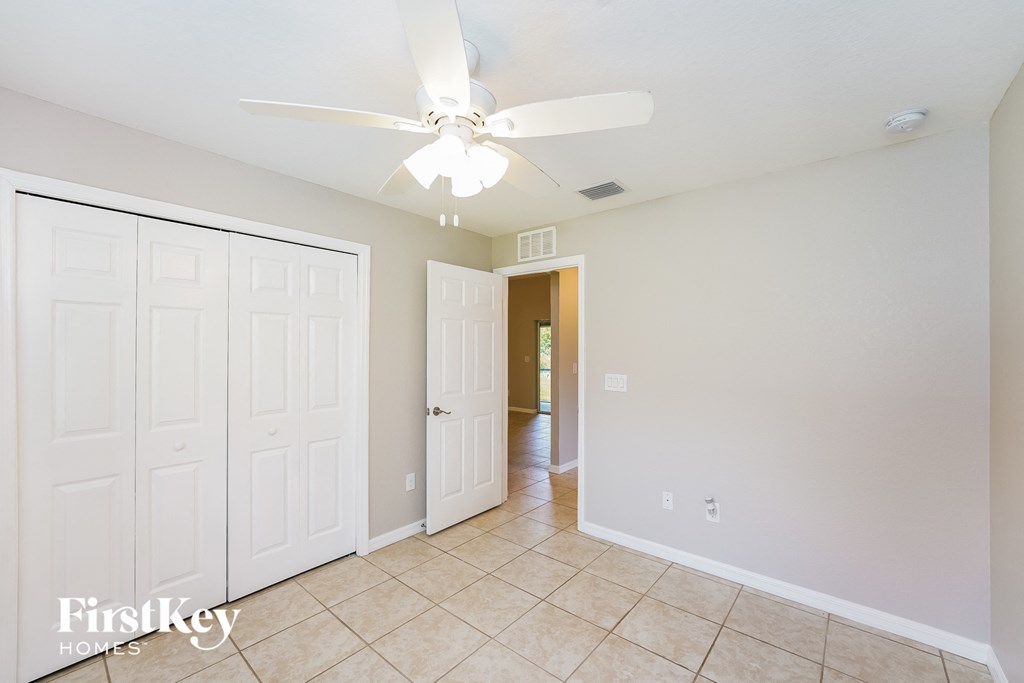 a bedroom with two closets and a ceiling fan