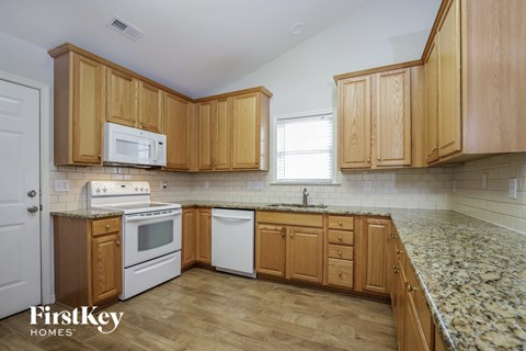 A kitchen with wooden cabinets and a granite countertop.