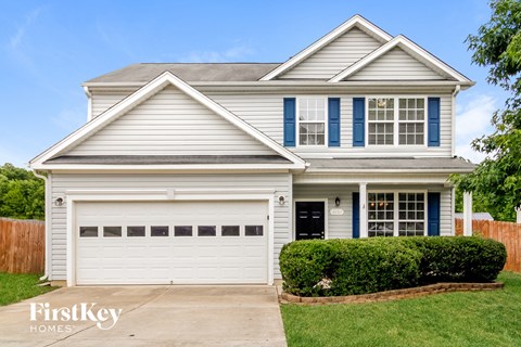 a white house with blue shutters and a white garage door