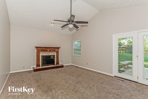 a living room with a fireplace and a ceiling fan