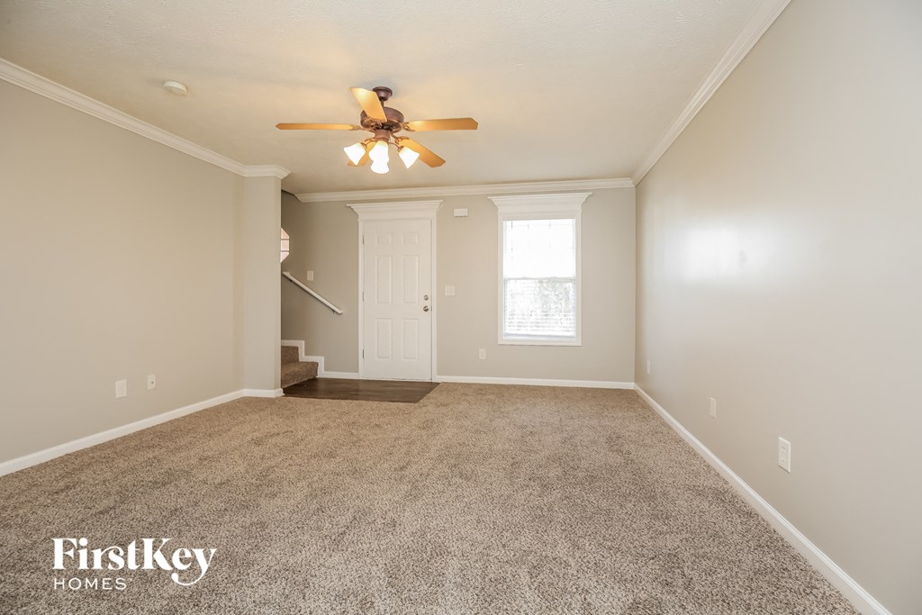 the master bedroom is spacious and has a ceiling fan and carpeting