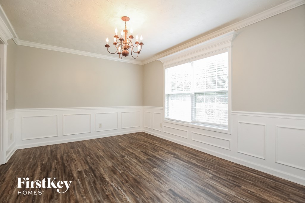 the living room of a home with wood flooring and a chandelier