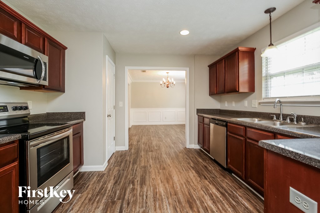 a kitchen with wood flooring and wooden cabinets and stainless steel appliances
