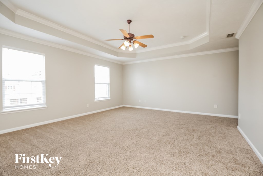 an empty living room with a ceiling fan