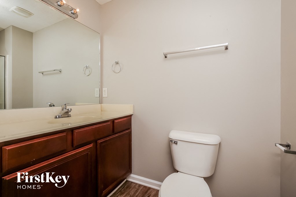a bathroom with a toilet and a sink and a mirror