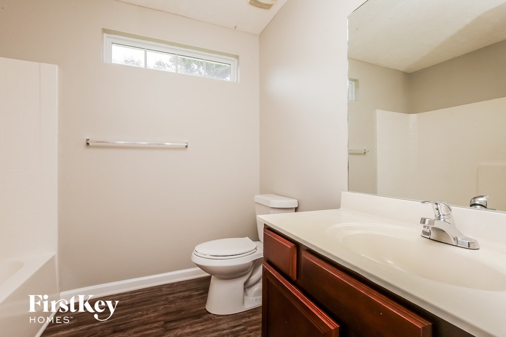 a bathroom with a toilet and a sink and a mirror