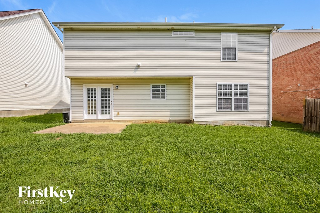 the front of a white house with a yard and grass
