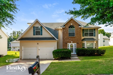 a suburban house with a white garage door and a lawn