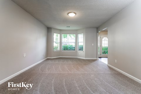 the living room and dining room of an empty house