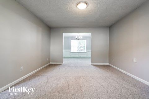 a empty room with a carpeted floor and a window