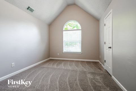 an empty room with carpet and a window